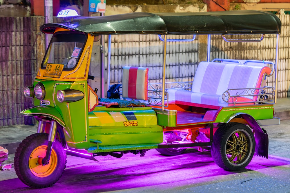 a brightly colored three wheeled vehicle parked on the side of the road