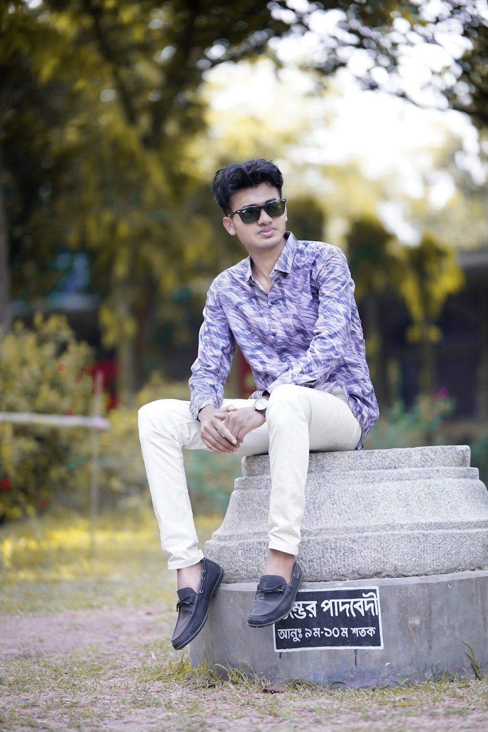 a man sitting on top of a cement block