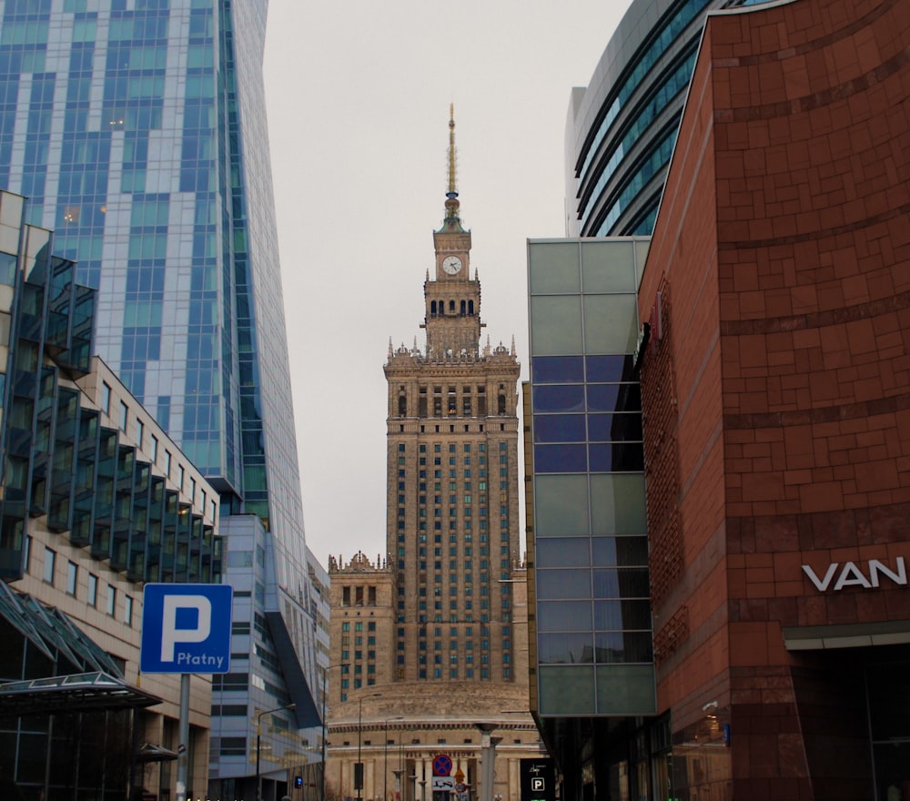 a city street with tall buildings and a clock tower