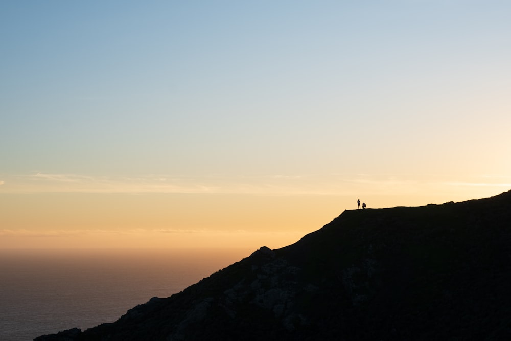 un couple de personnes debout au sommet d’une colline