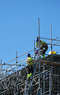 two construction workers working on scaffolding on a building