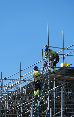 two construction workers working on scaffolding on a building