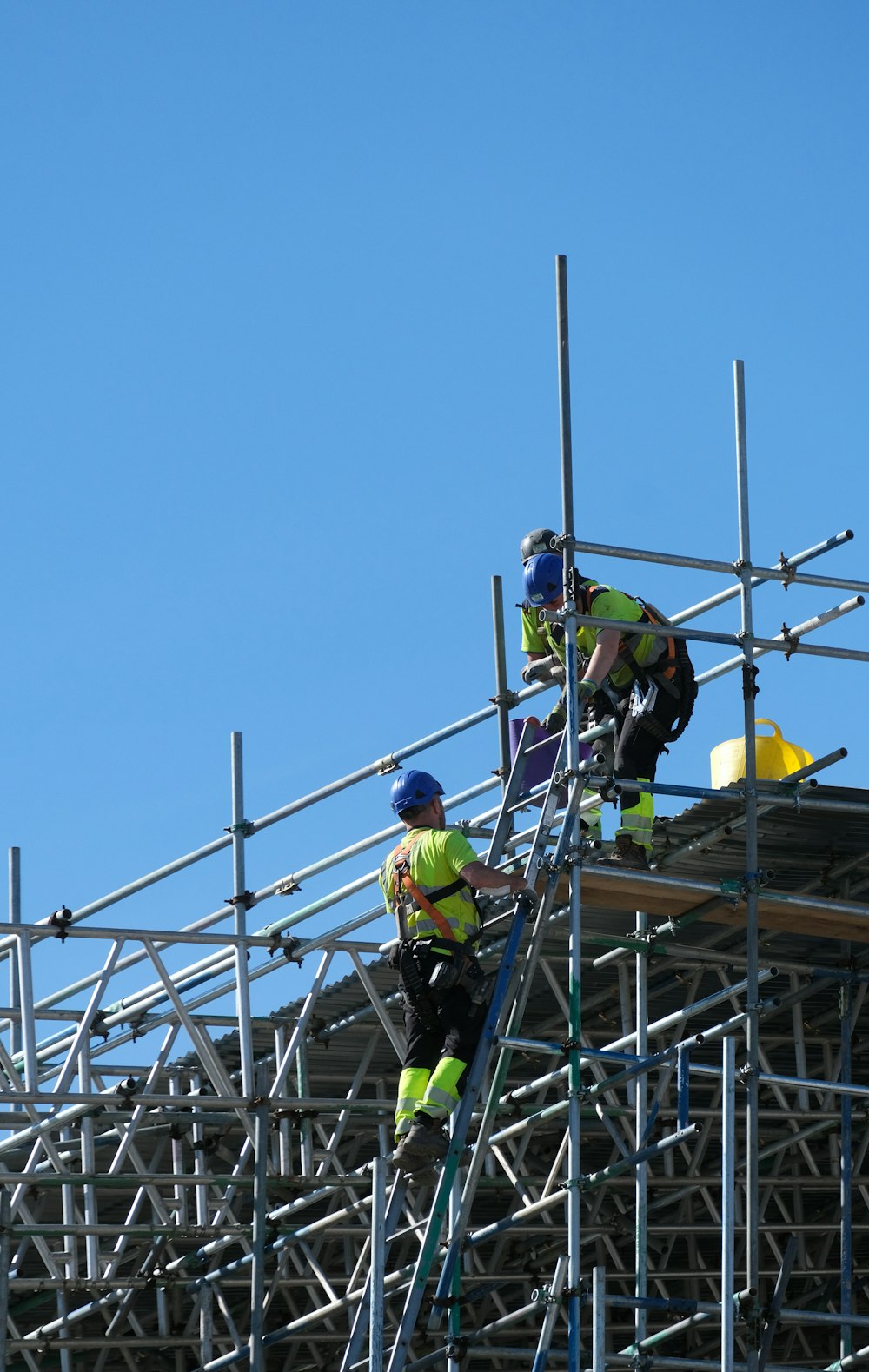 two construction workers working on scaffolding on a building