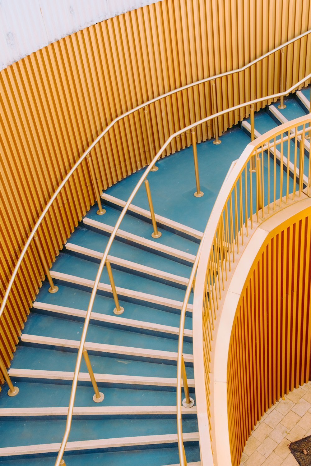 a yellow and blue spiral staircase next to a wall