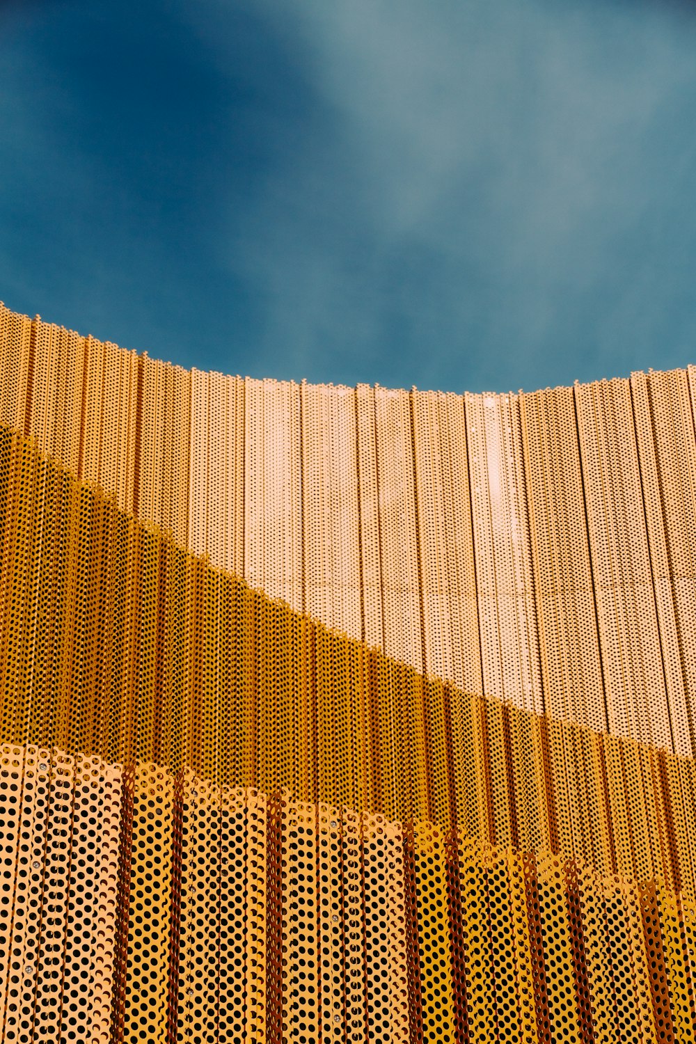 a building made of wooden slats with a blue sky in the background