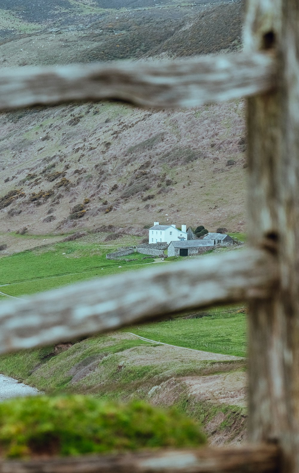 a small white house in the middle of a field