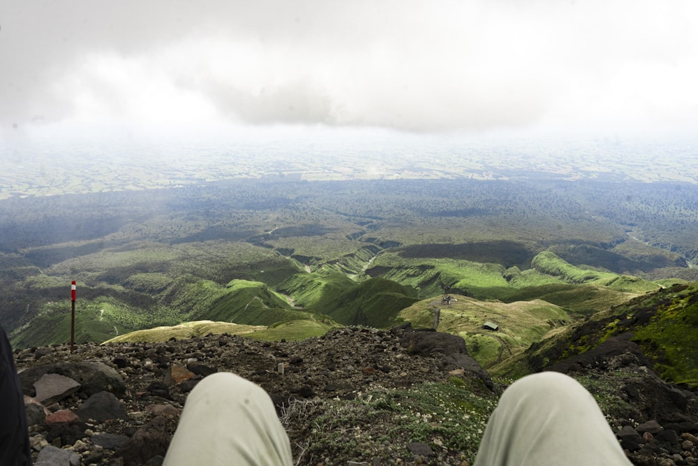 a person sitting on top of a mountain with their feet up