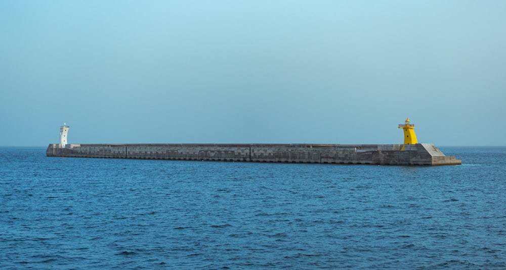 a large body of water with a light house in the middle of it