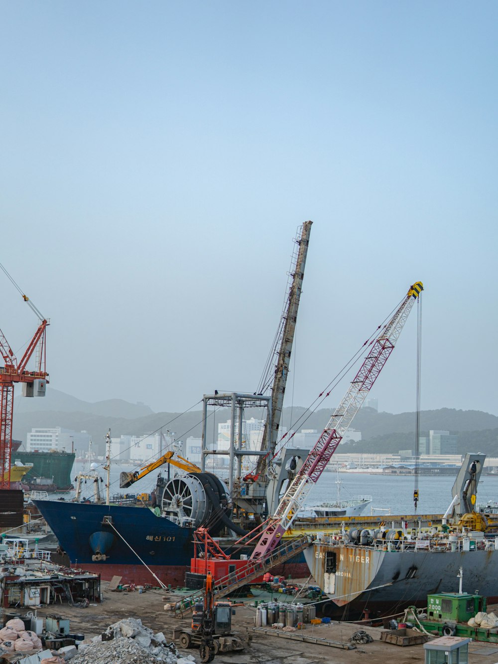 a crane is standing next to a large boat