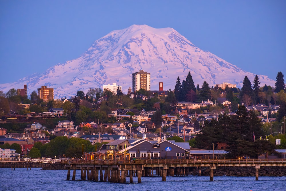 a large snow covered mountain towering over a city