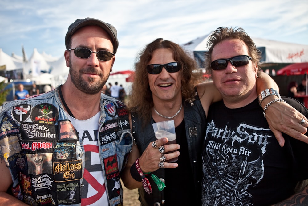 a group of three men standing next to each other