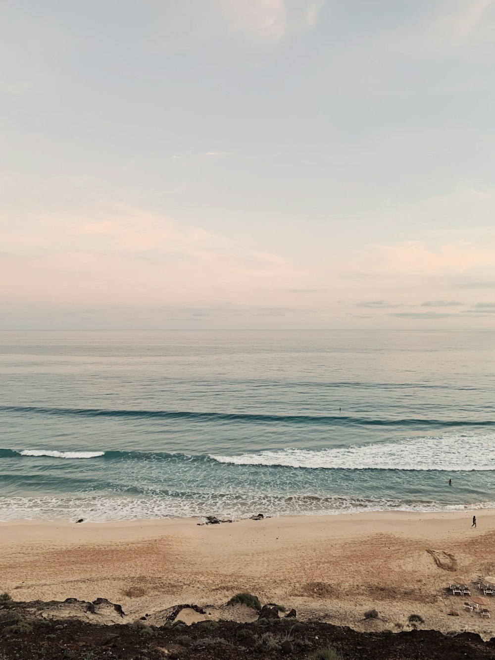 a person walking on the beach with a surfboard