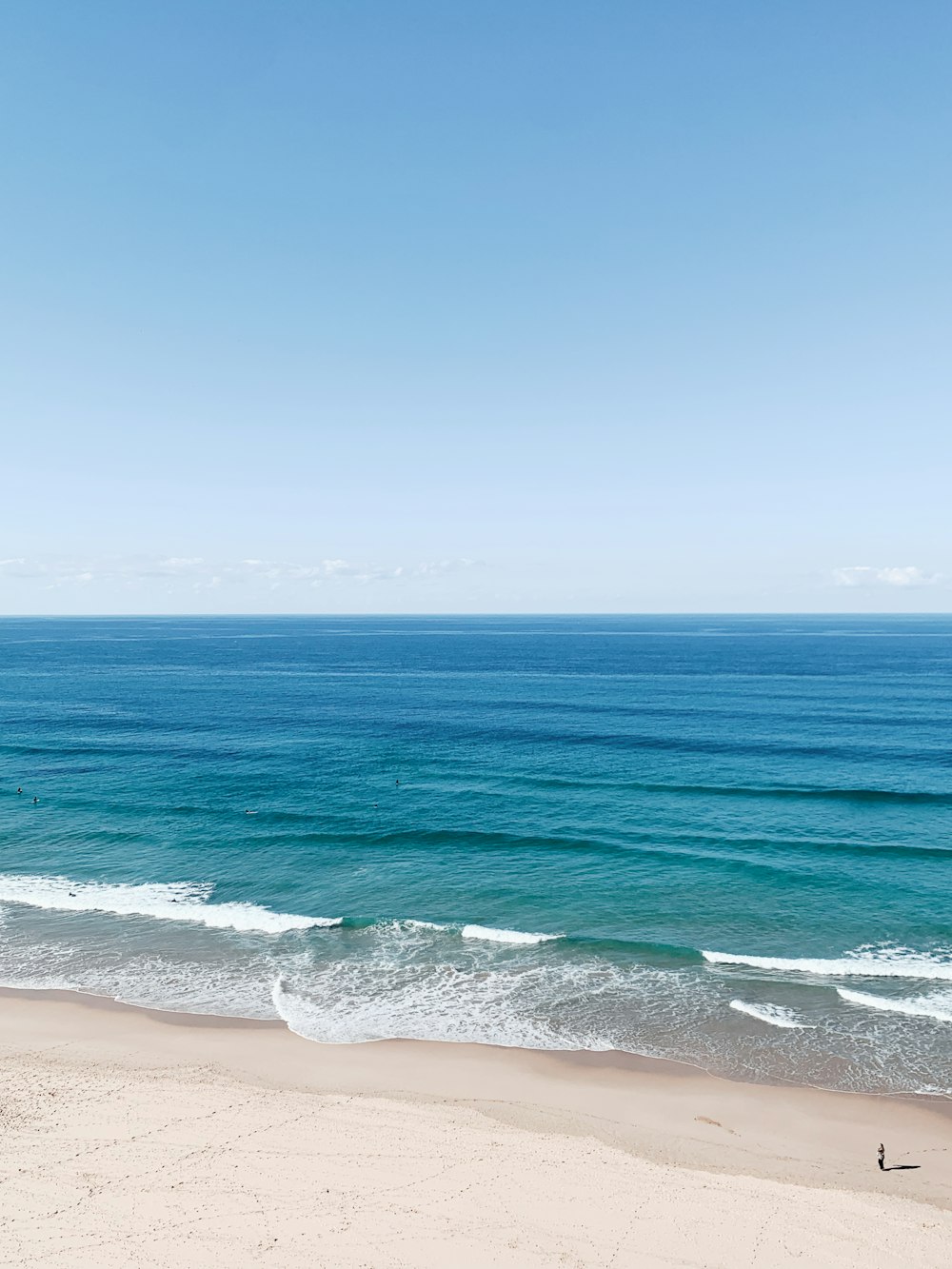 a person walking on a beach near the ocean