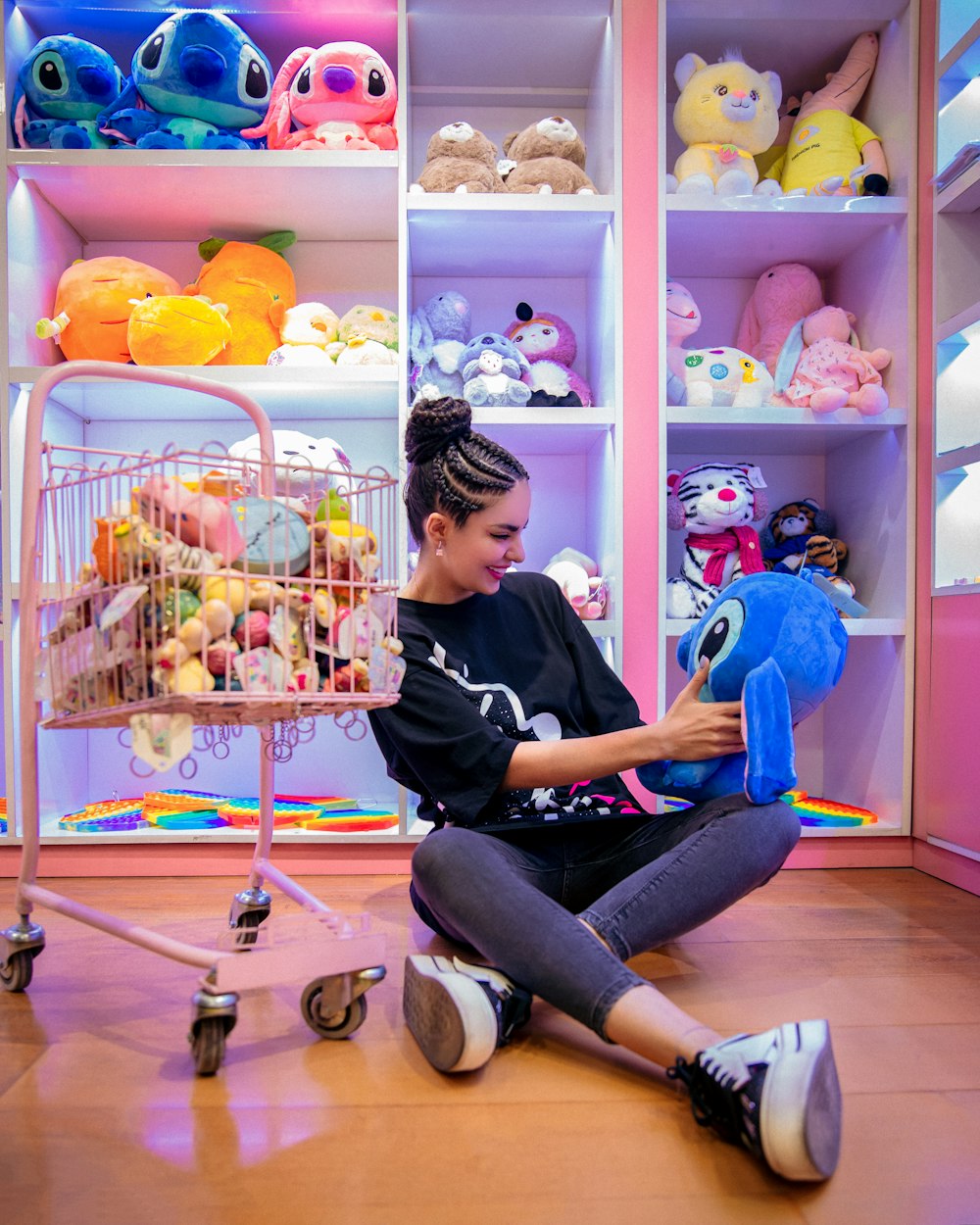 a woman sitting on the floor with a stuffed animal