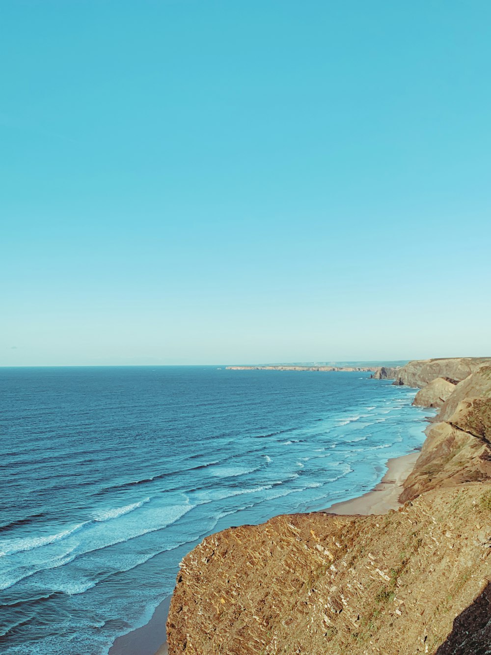 a view of the ocean from the top of a hill