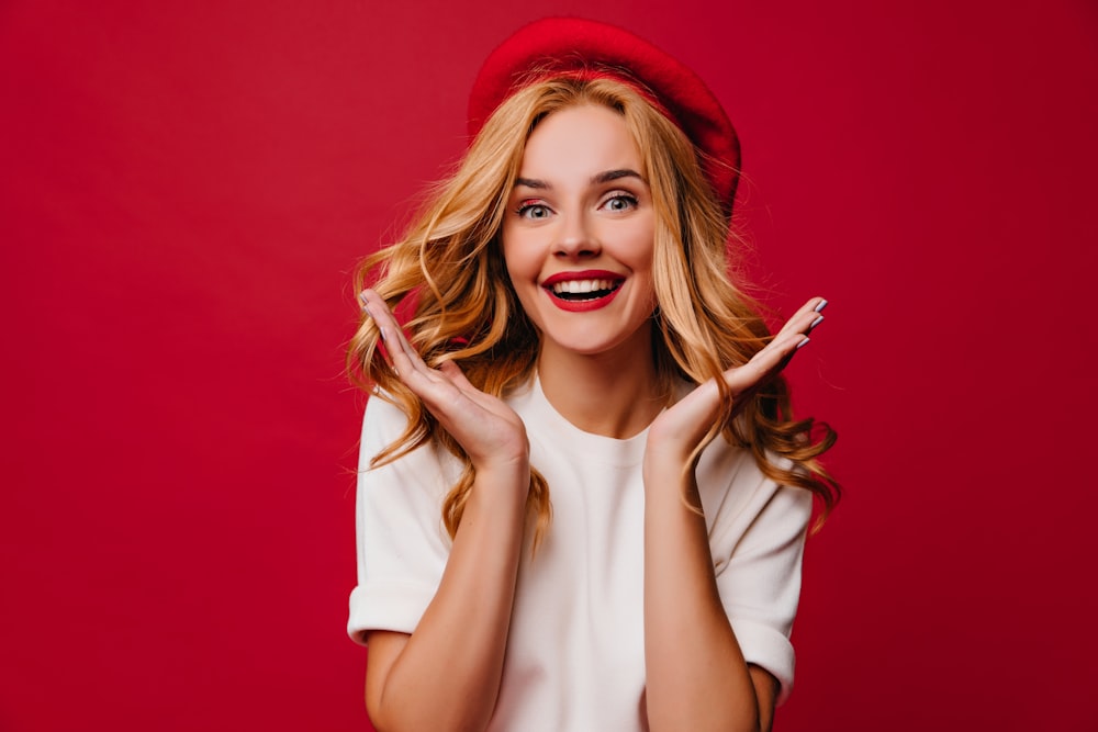 a woman wearing a red hat making a funny face