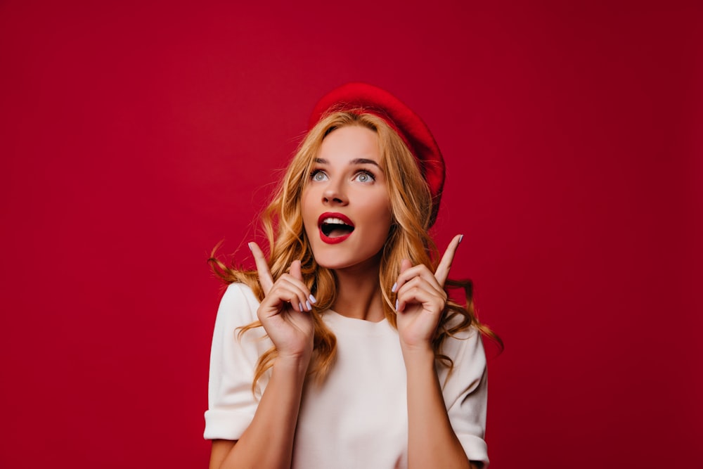 a woman wearing a red hat making a funny face