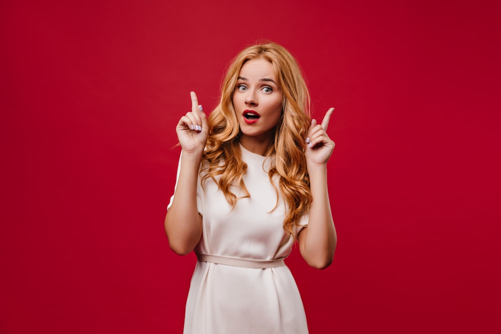 a woman in a white dress making a funny face