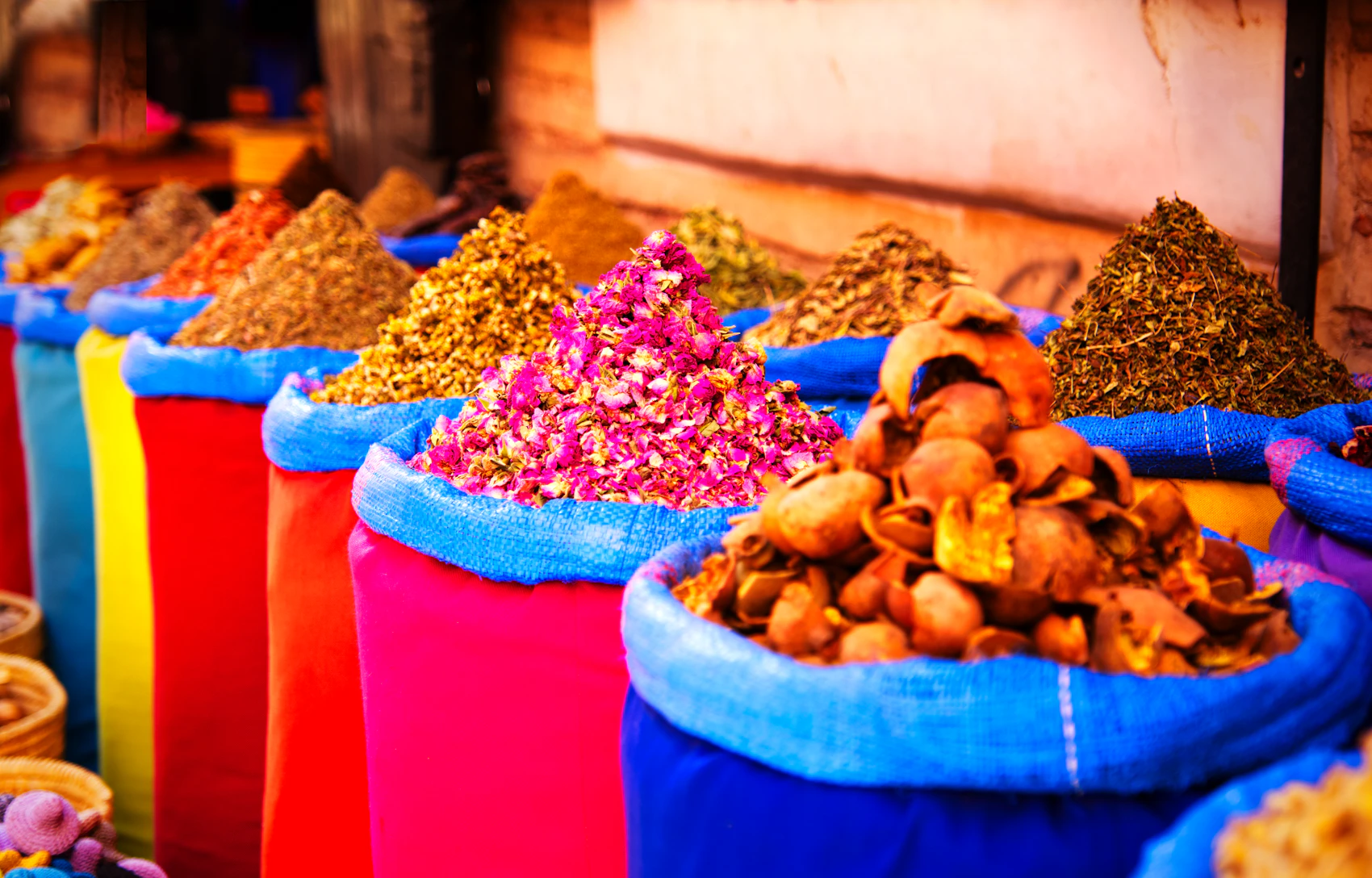 Colourful spices displayed in open sacks inside a Marrakech souk
