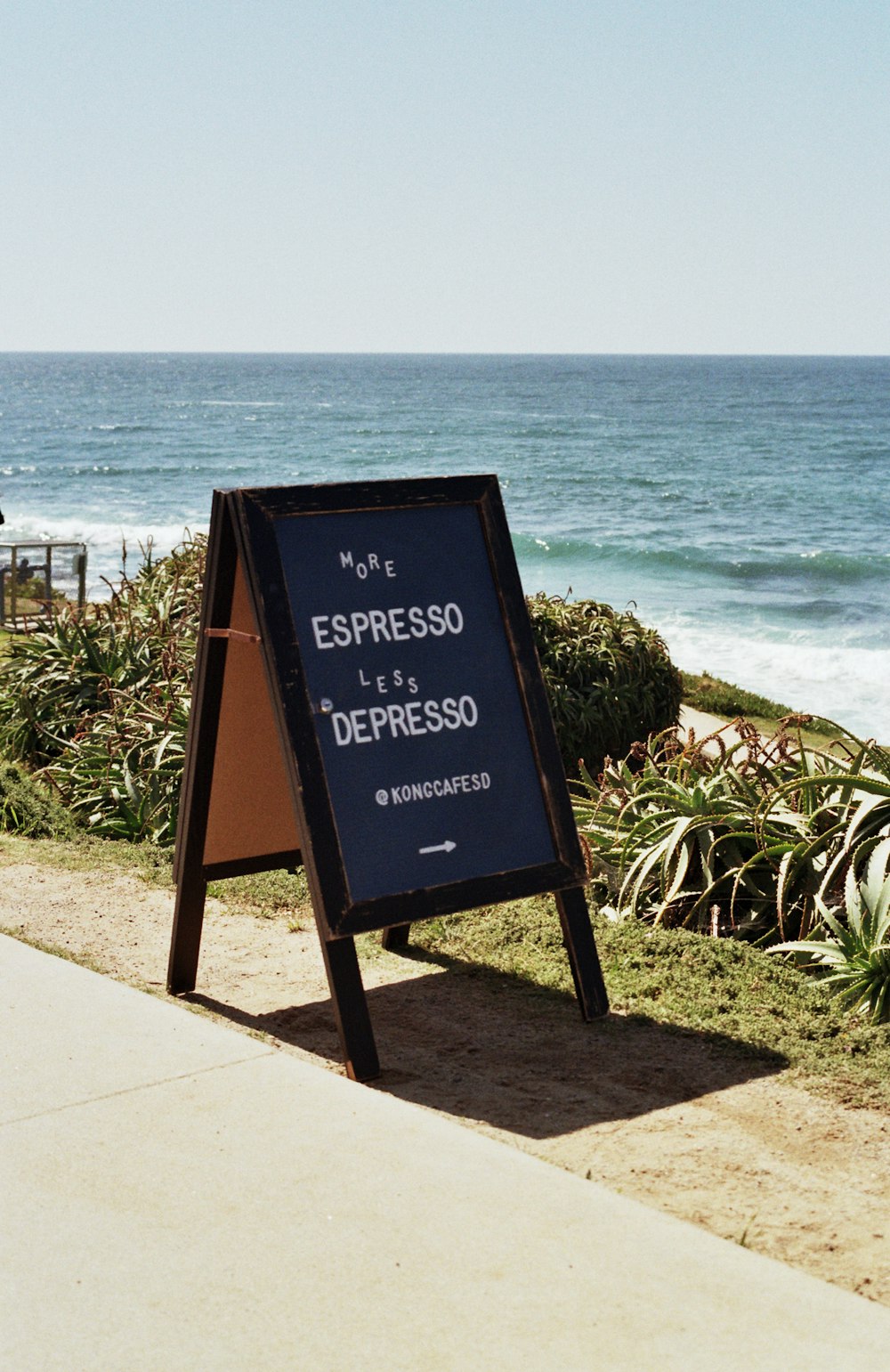 a sign on the side of a road near the ocean