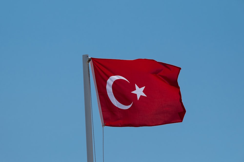 a red flag with a white star and a crescent on it