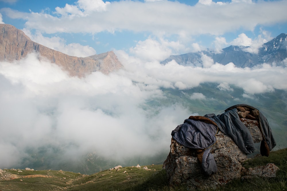 a blanket on top of a rock in the mountains