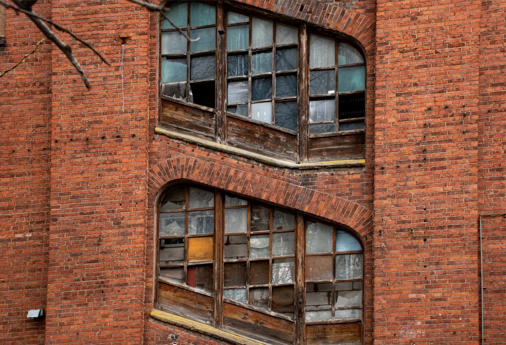 ein altes Backsteingebäude mit zerbrochenen Fenstern