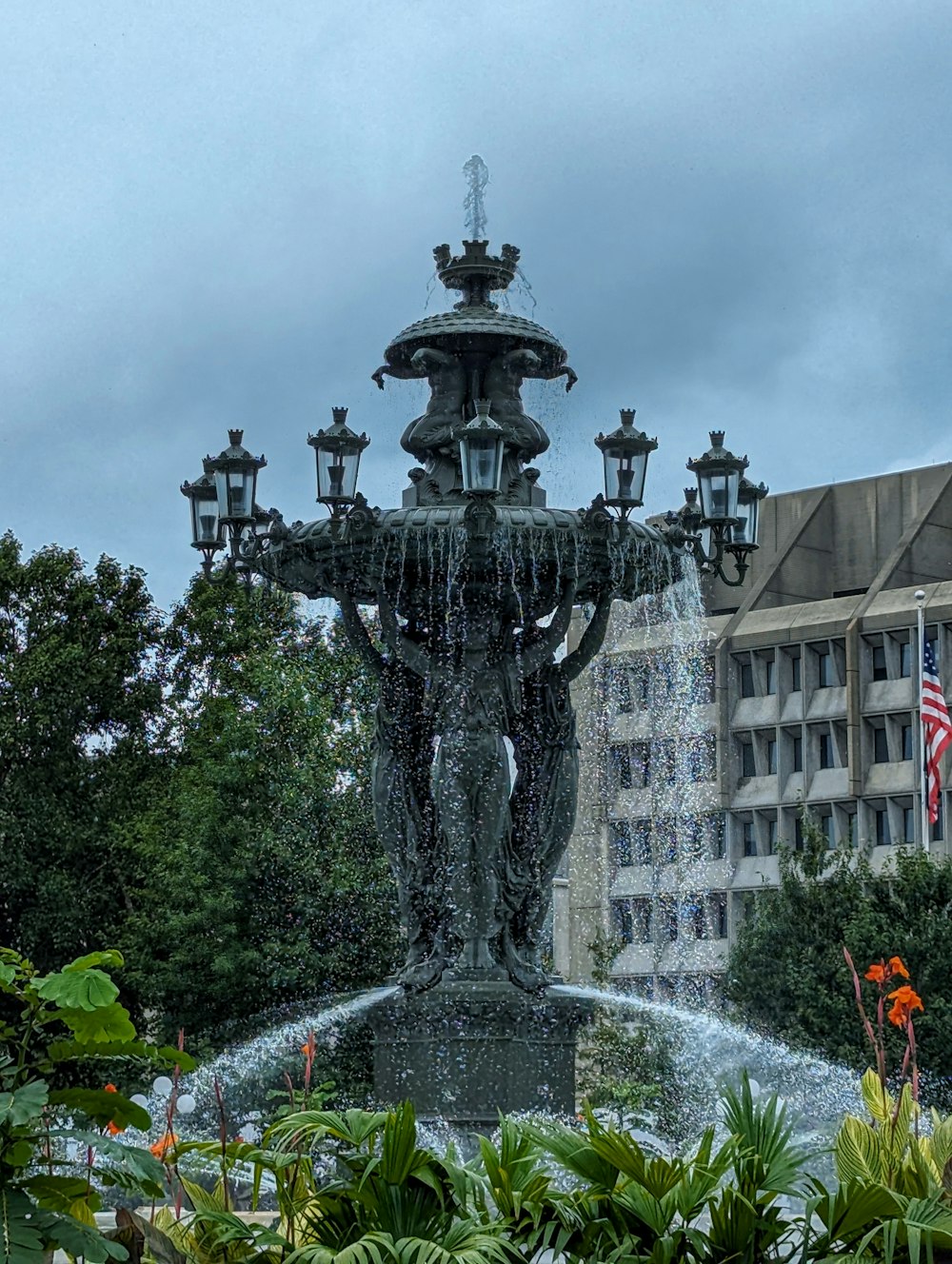 a water fountain with a clock tower in the background