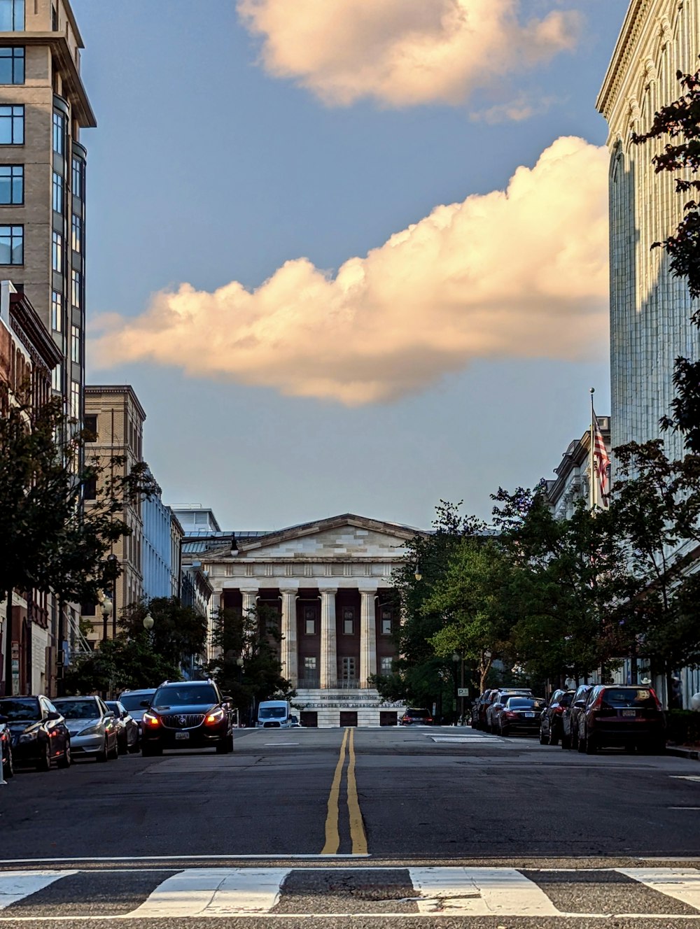 a city street with cars parked on both sides of it