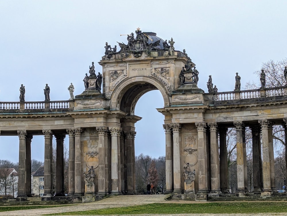 a large stone arch with statues on top of it