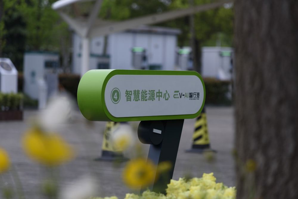 a green and white sign sitting next to a tree