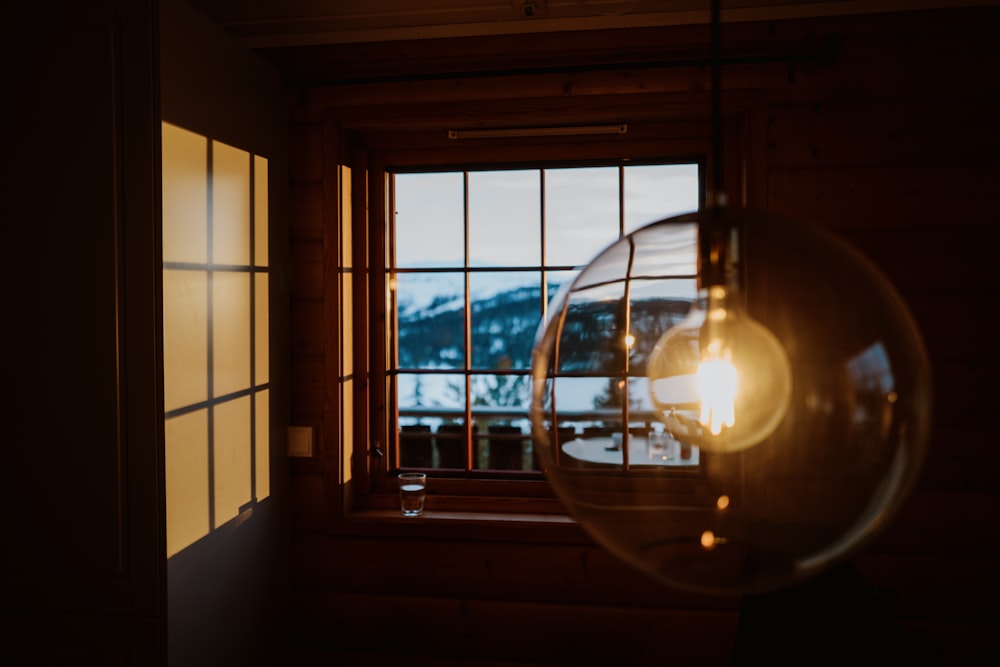 a light bulb hanging from a window next to a window