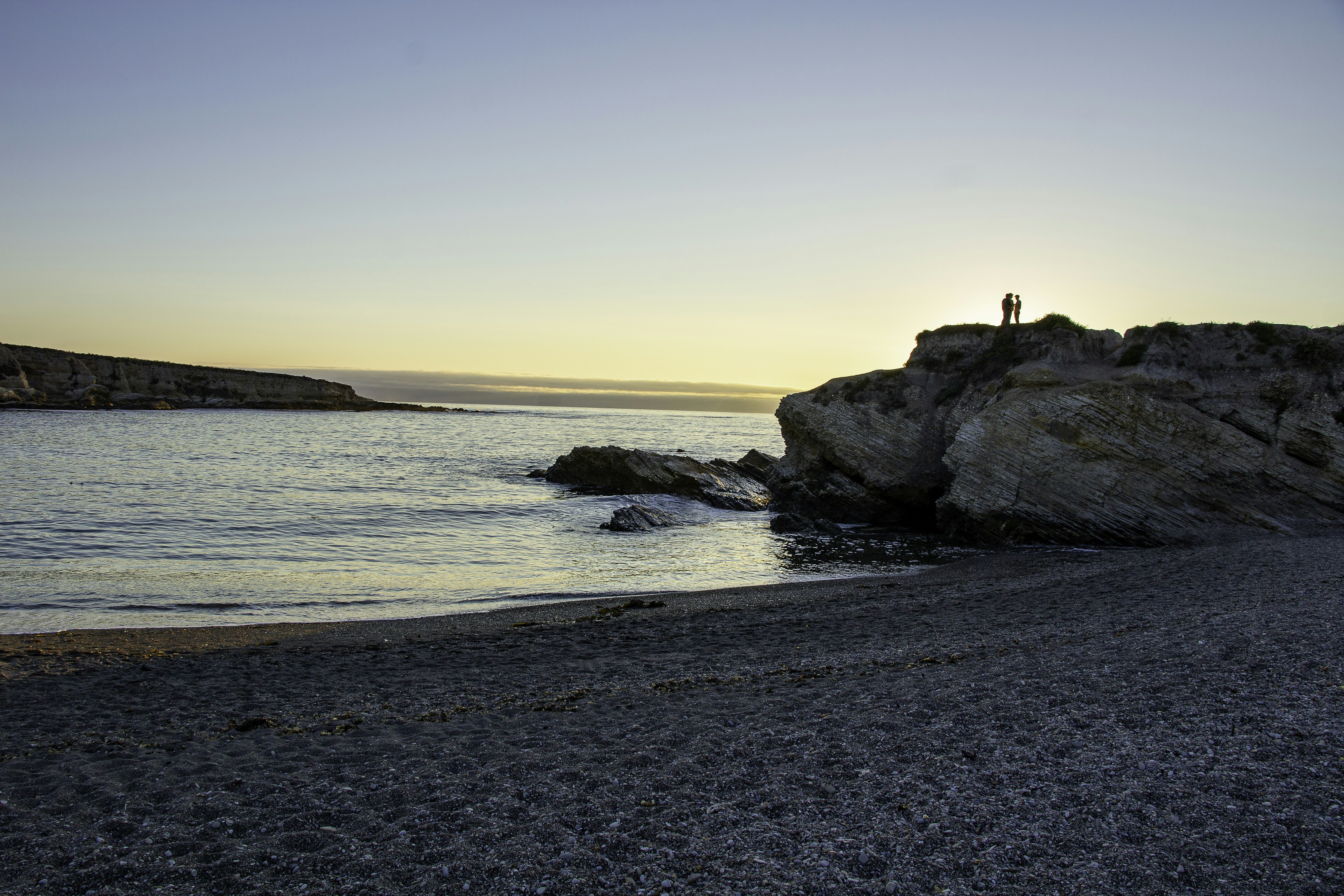 a person standing on a beach next to a body of water