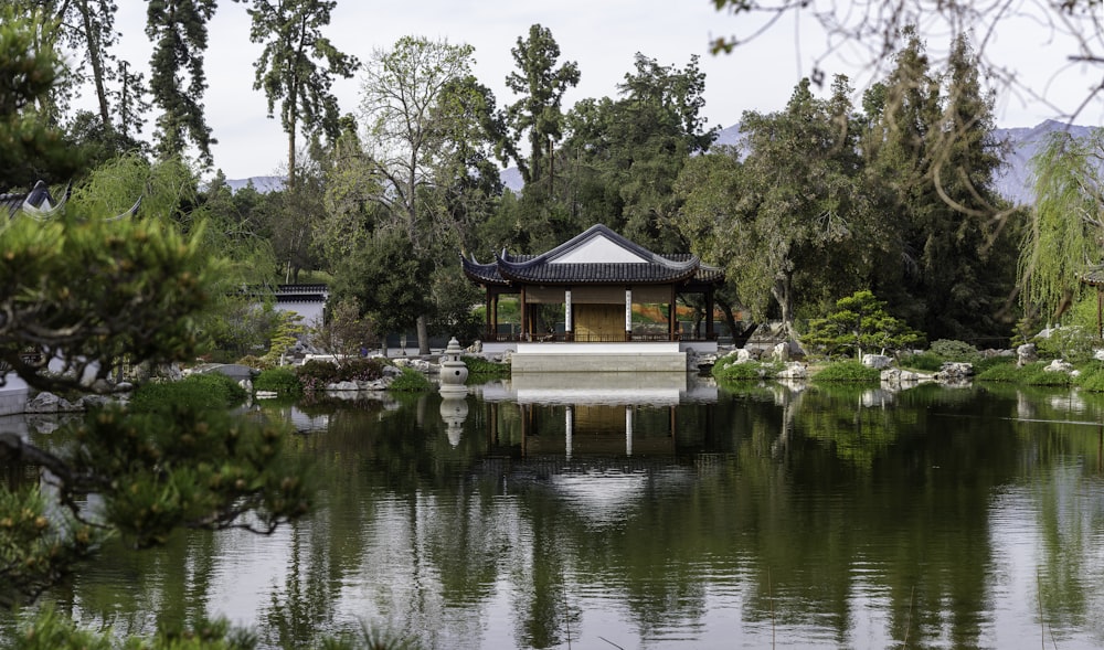 a pond with a pavilion in the middle of it