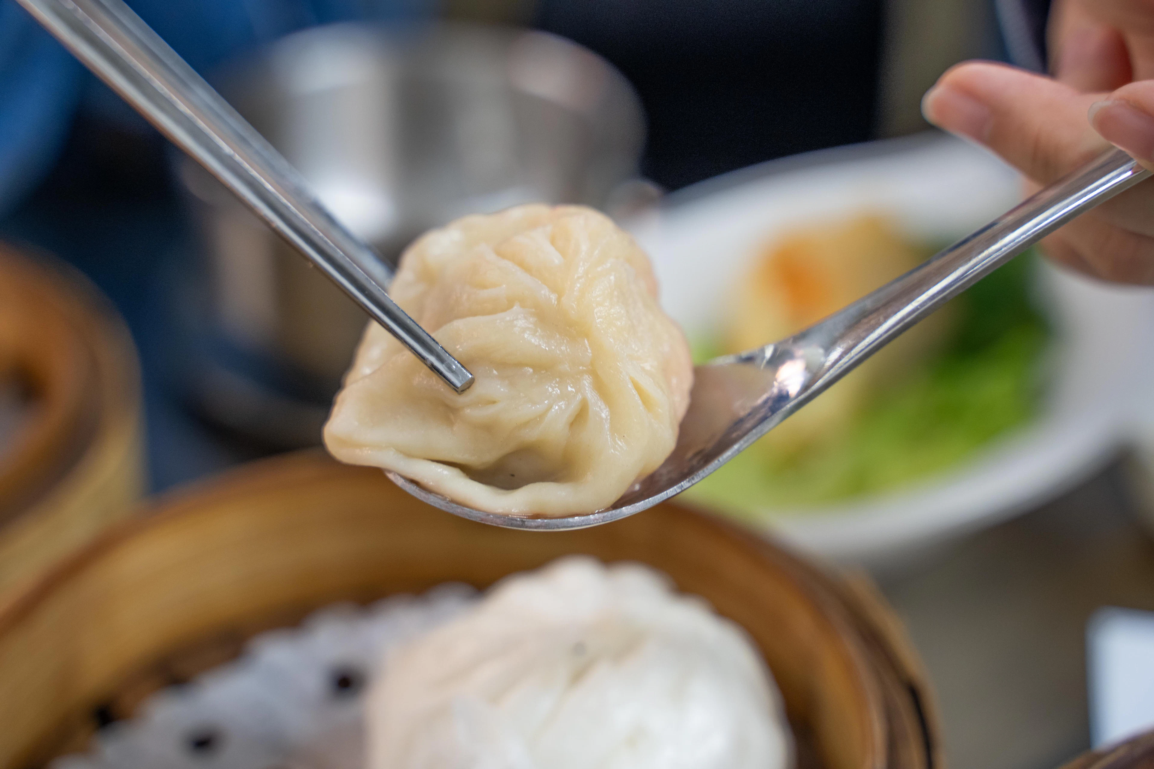 Dim sum koldūnas ant šaukšto virš bambukinio garinimo krepšelio Honkonge