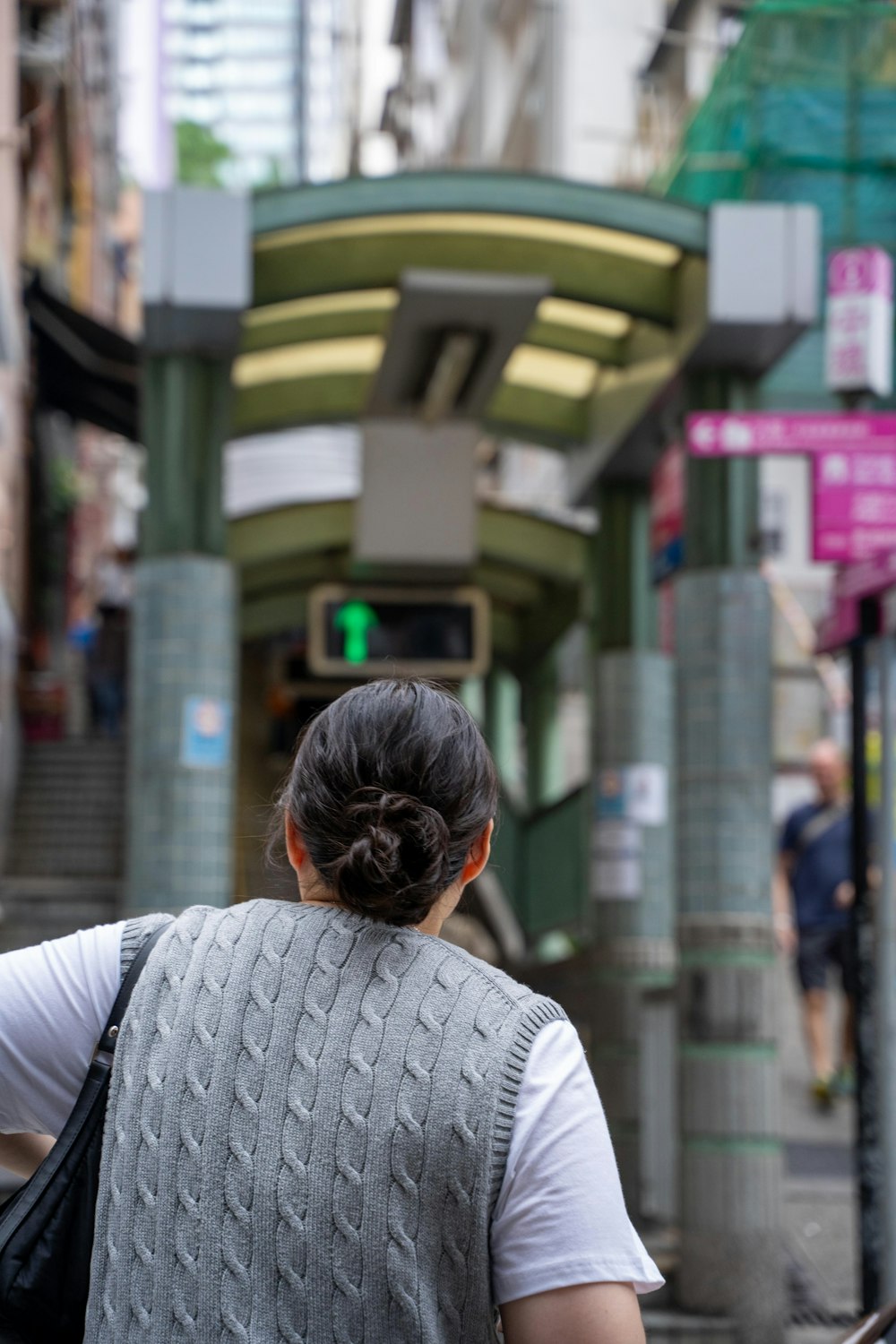 a woman walking down a street next to a building