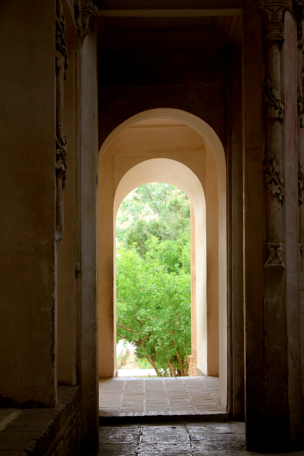 an archway leading into a lush green forest