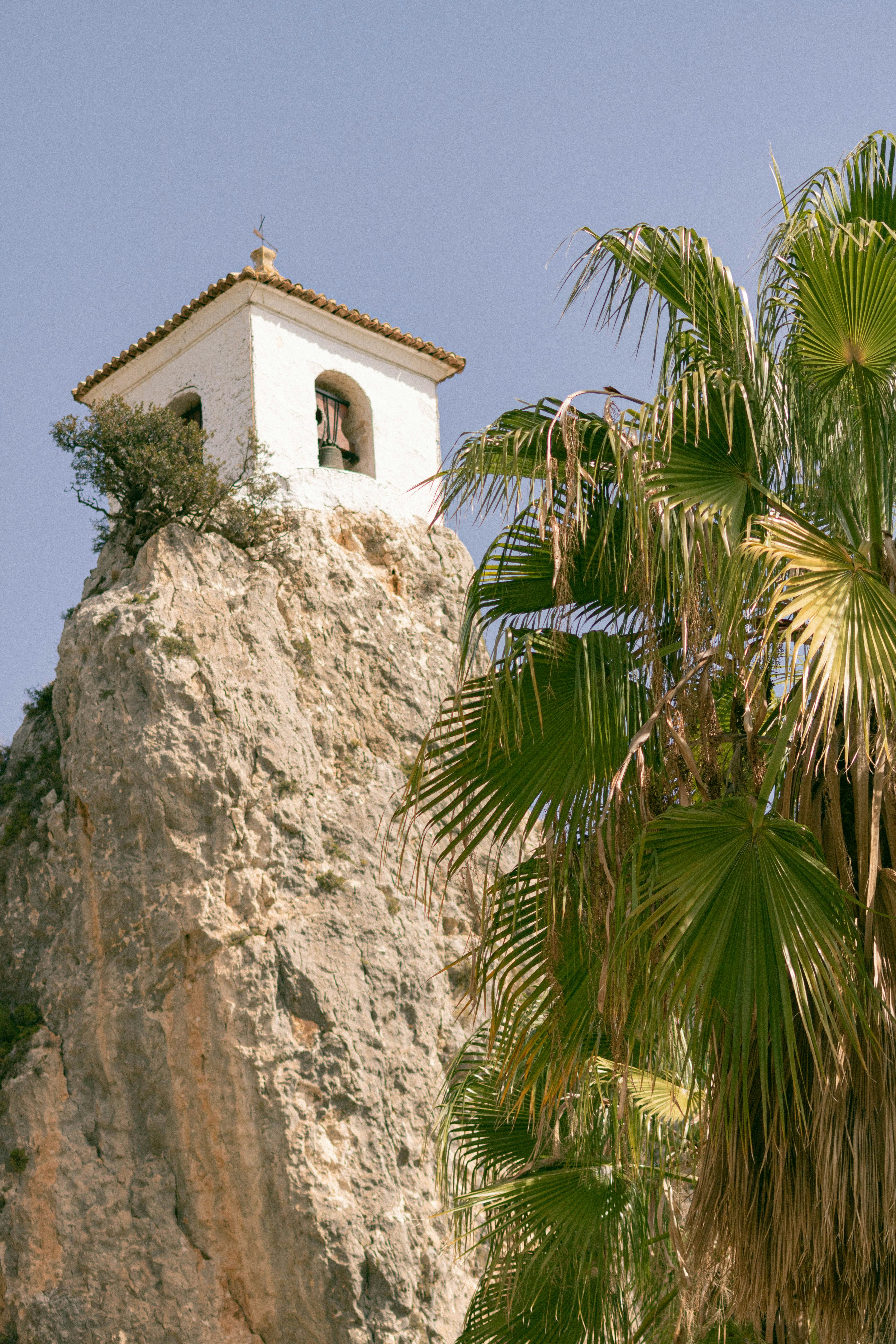 a white clock tower on top of a mountain