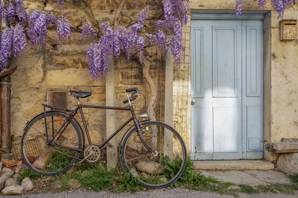 una bicicletta parcheggiata accanto a un edificio con una porta blu