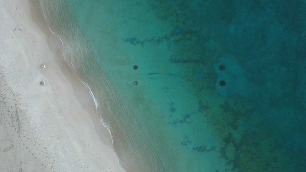 an aerial view of a sandy beach with blue water