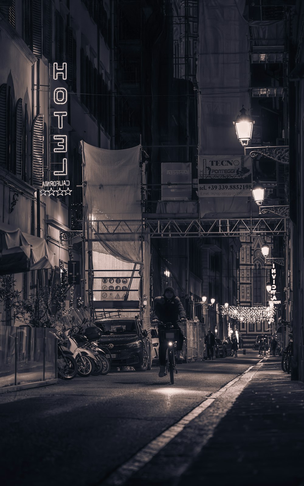 a man riding a bike down a street at night