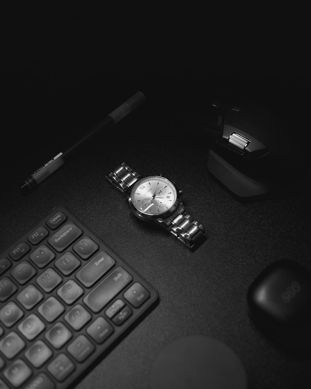 a black and white photo of a watch and a keyboard