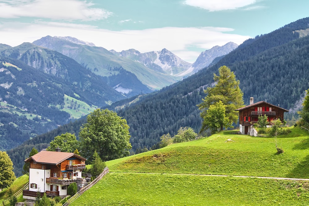 a house on a hill with mountains in the background