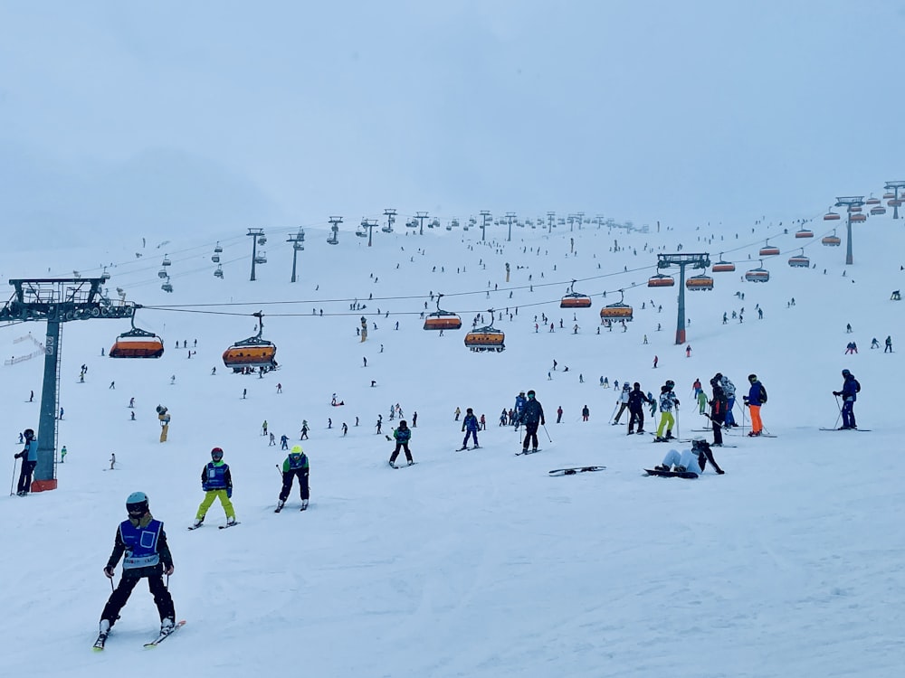 a group of people riding skis down a snow covered slope