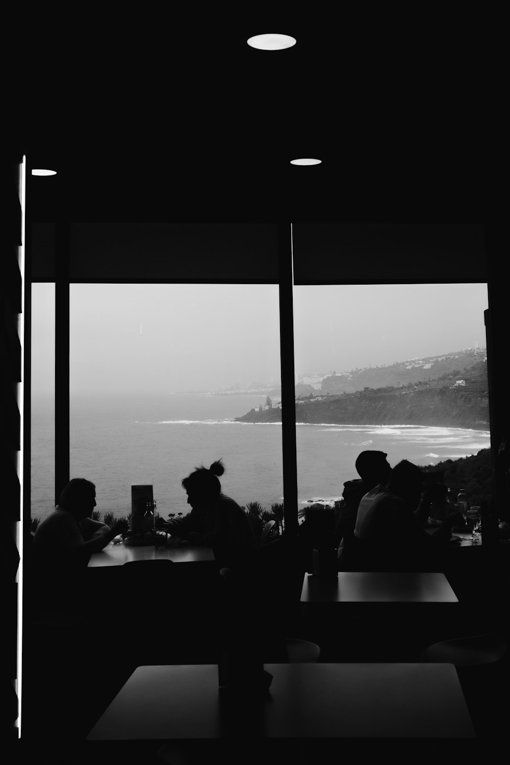 a group of people sitting at a table in front of a window