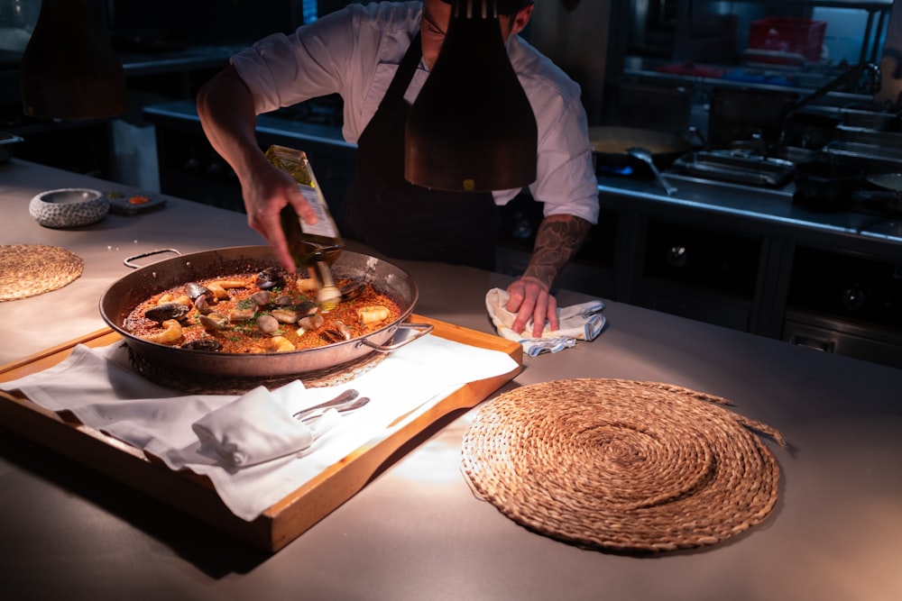 a man in a kitchen preparing a dish of food