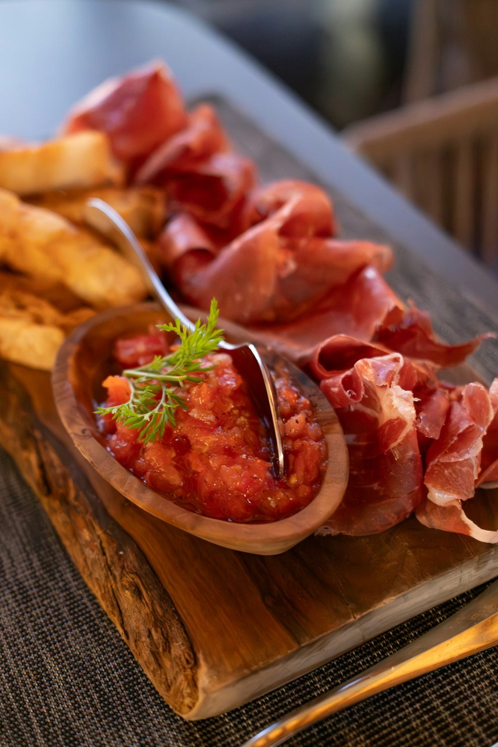 a wooden plate topped with meat and french fries