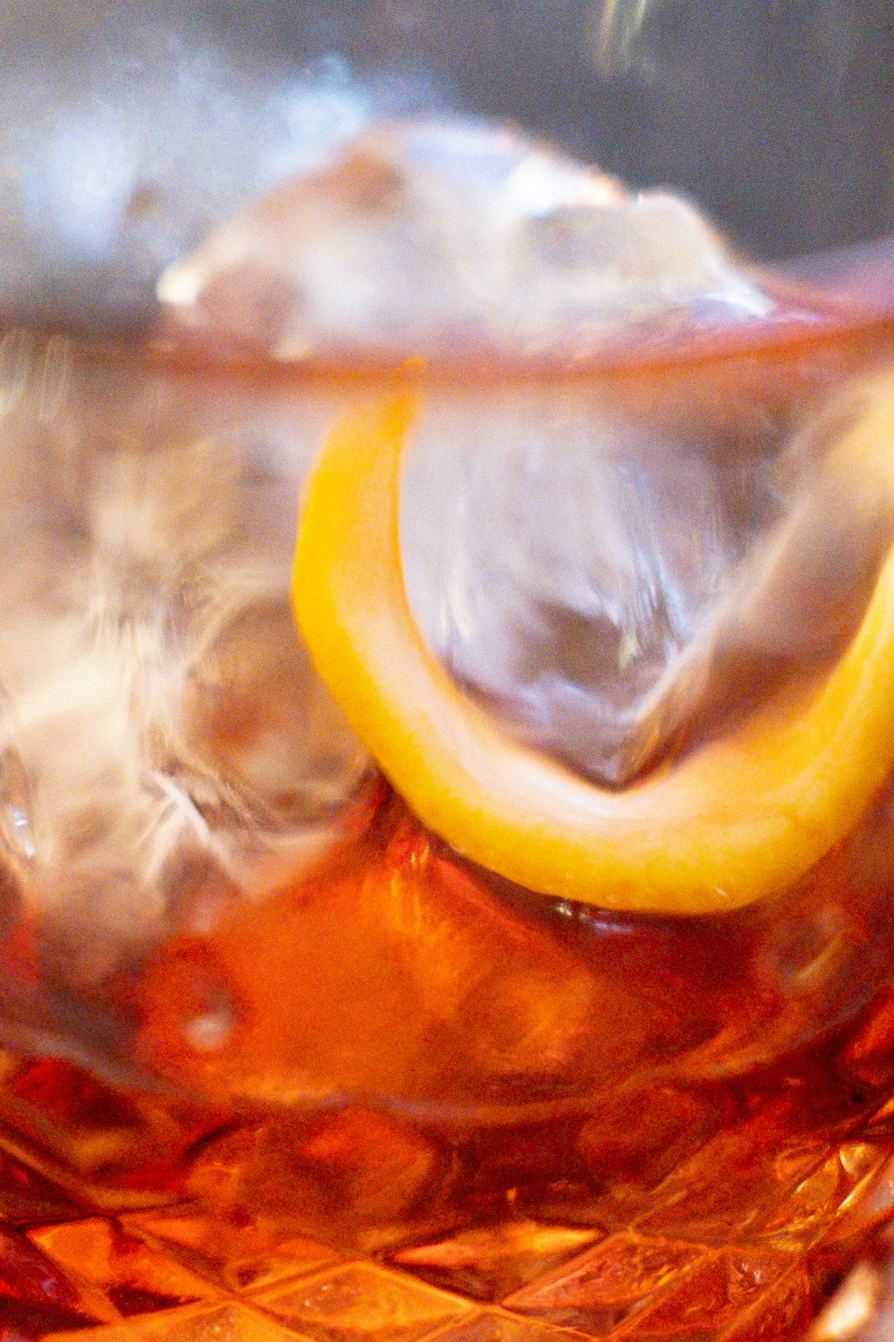 a close up of a glass with ice and a lemon