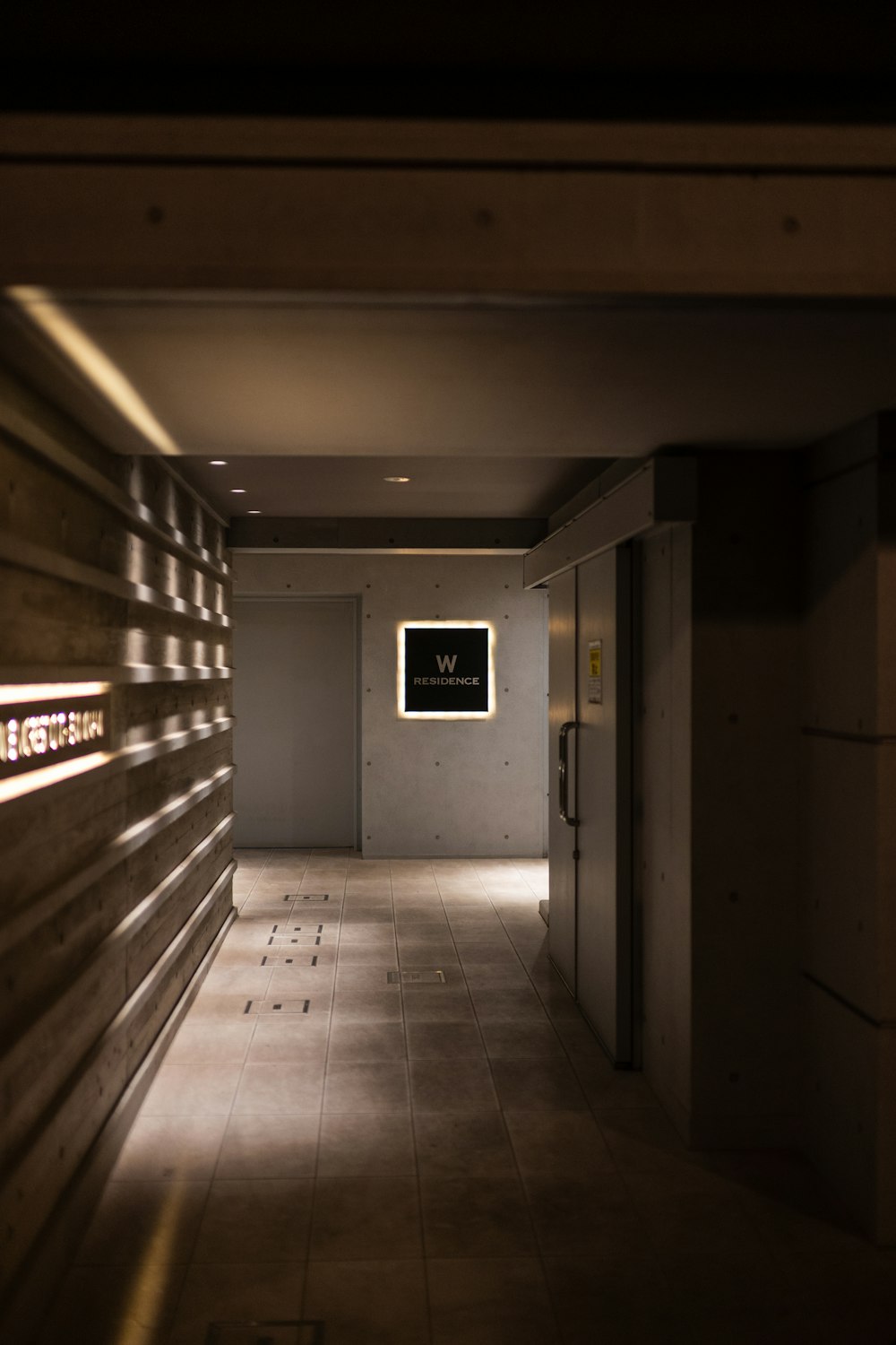 a dimly lit hallway with a clock on the wall