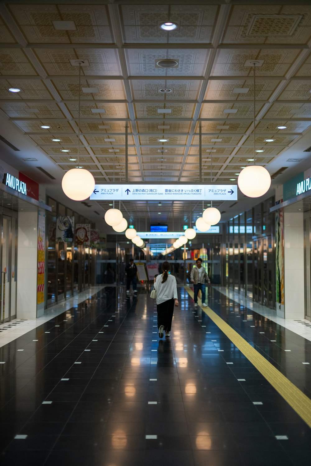 a group of people walking down a long hallway